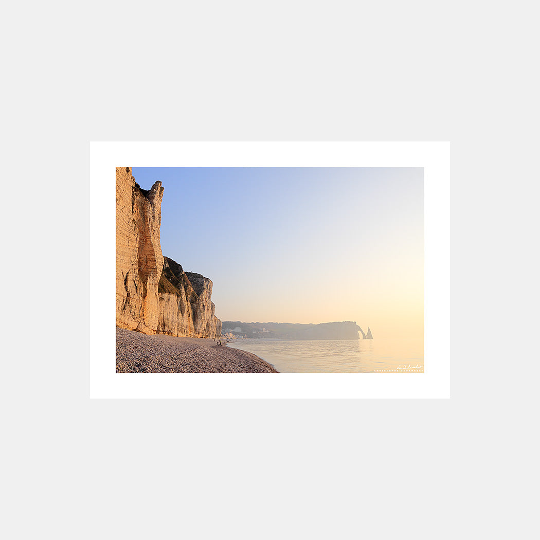 Photographie des falaises d'Etretat, avec la Porte d'Aval et l'Aiguille au couchant depuis la plage de galets, Côte d'Albâtre, Seine-Maritime, Normandie, France.