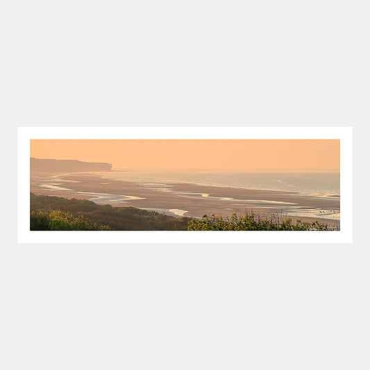 Photographie panoramique de la plage à marée basse sur le secteur Omaha Beach depuis le WN62 de Colleville-sur-Mer au soleil couchant en été avec la Pointe de la Percée, Débarquement du 6 juin 1944, Calvados, Normandie, France.