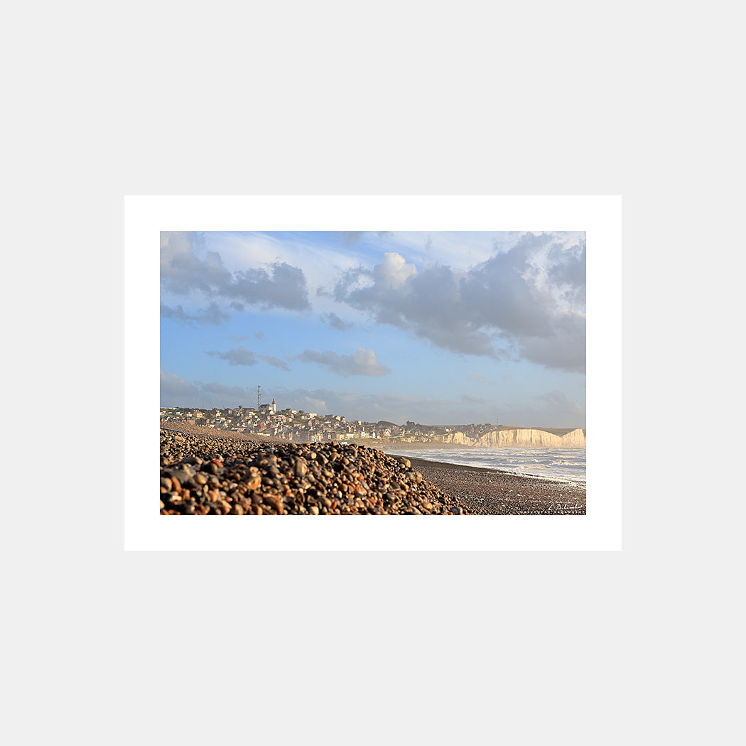 Photographie du phare et des falaises de Ault sous les embruns du large depuis la plage de galets au soleil couchant, Côte Picarde, Somme, Hauts-de-France, France.