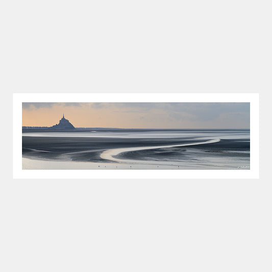 Photographie panoramique du Mont-Saint-Michel et des bancs de sable de la baie à marée basse au soleil couchant, Cotentin, Manche, Normandie, France.