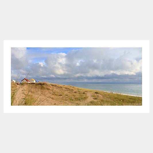 Photographie des cabines de plage de Gouville-sur-Mer dans les dunes avec la mer sous le soleil couchant, Cotentin, Manche, Normandie, France.