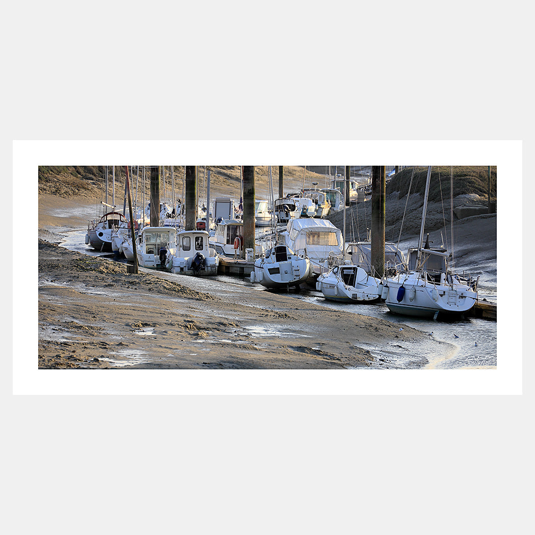 Photographie des voiliers et bateaux de plaisance dans le port du Hourdel à marée basse au couchant, Baie de Somme, Côte Picarde, Somme, Hauts-de-France, France.