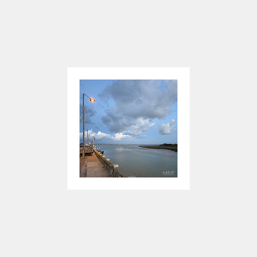 Photographie du quai du port du Hourdel avec les bateaux de pêche à la tombée de la nuit, Baie de Somme, Côte Picarde, Somme, Hauts-de-France, France.