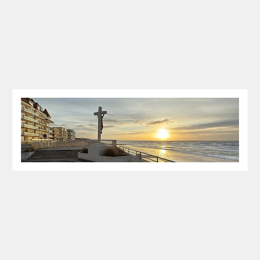 Photographie panoramique du front de mer de Merlimont Plage avec le calvaire des marins face au coucher du soleil, Côte d'Opale, Pas-de-Calais, Hauts-de-France, France.